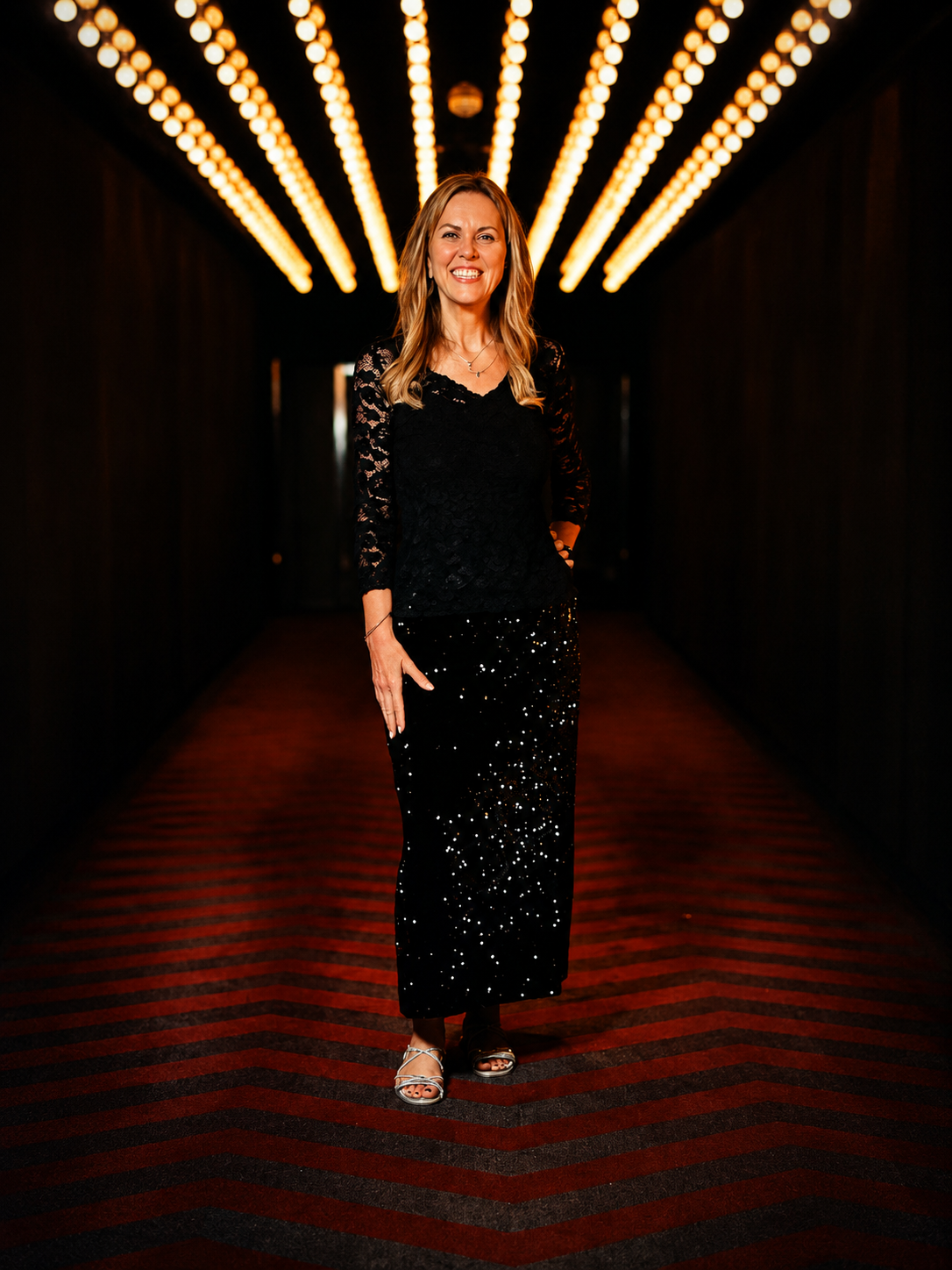 Julie Begbie at an awards evening, wearing a black lace top and sequin skirt